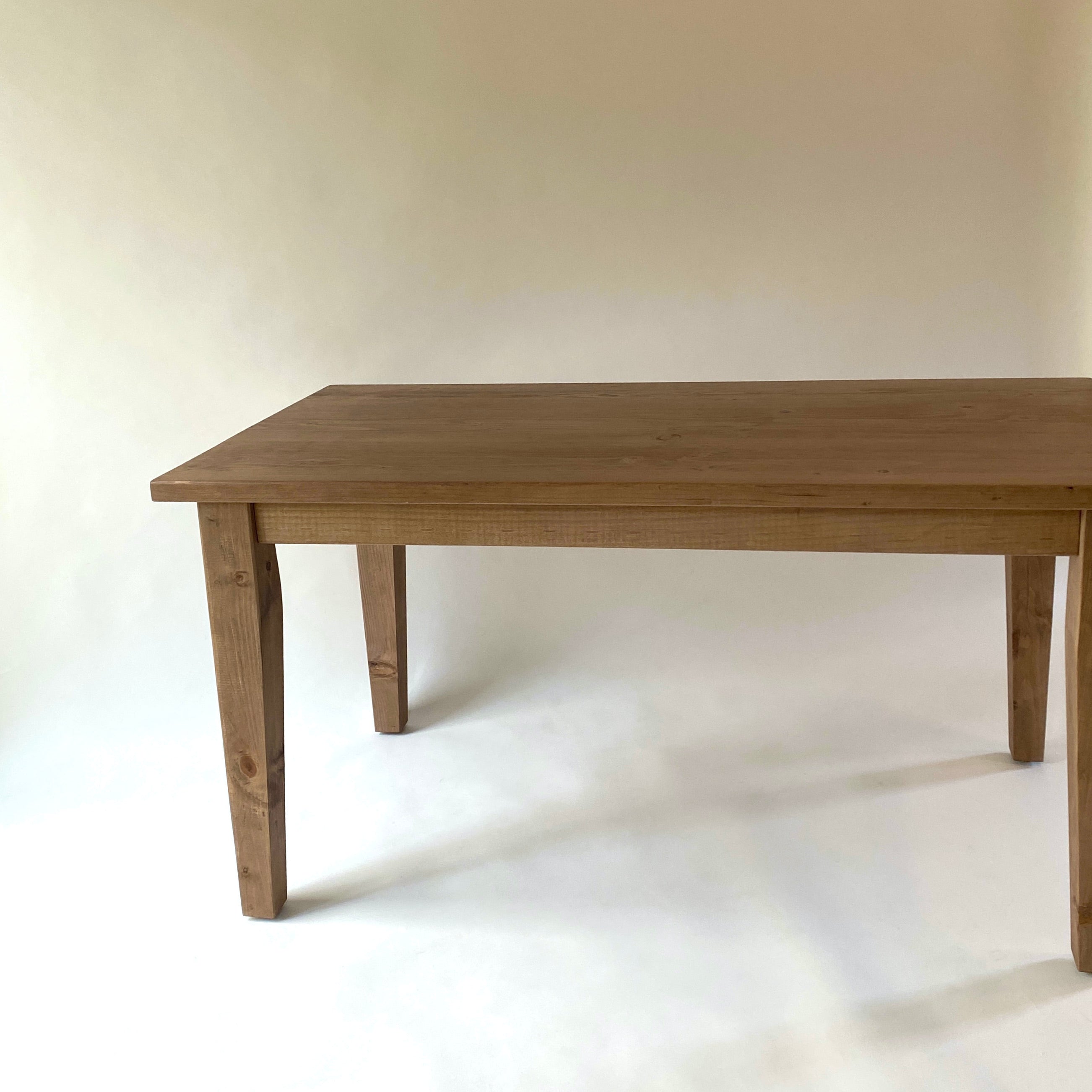 A rectangular brown French farmhouse style desk with tapered legs and a subtle overhang on the ends.