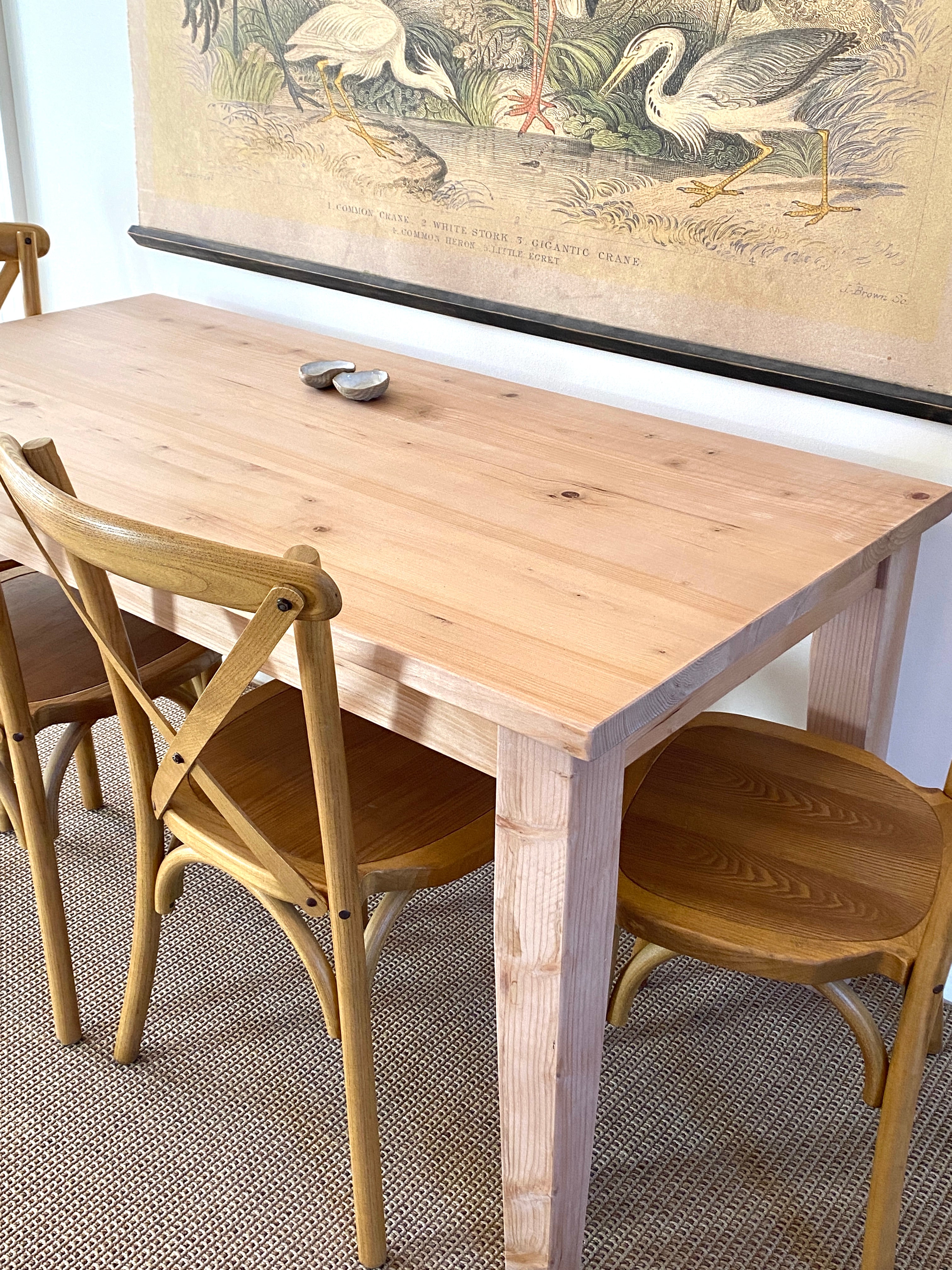 A provincial farmhouse style wooden table with tapered legs, accompanied by matching chairs. Solid wood